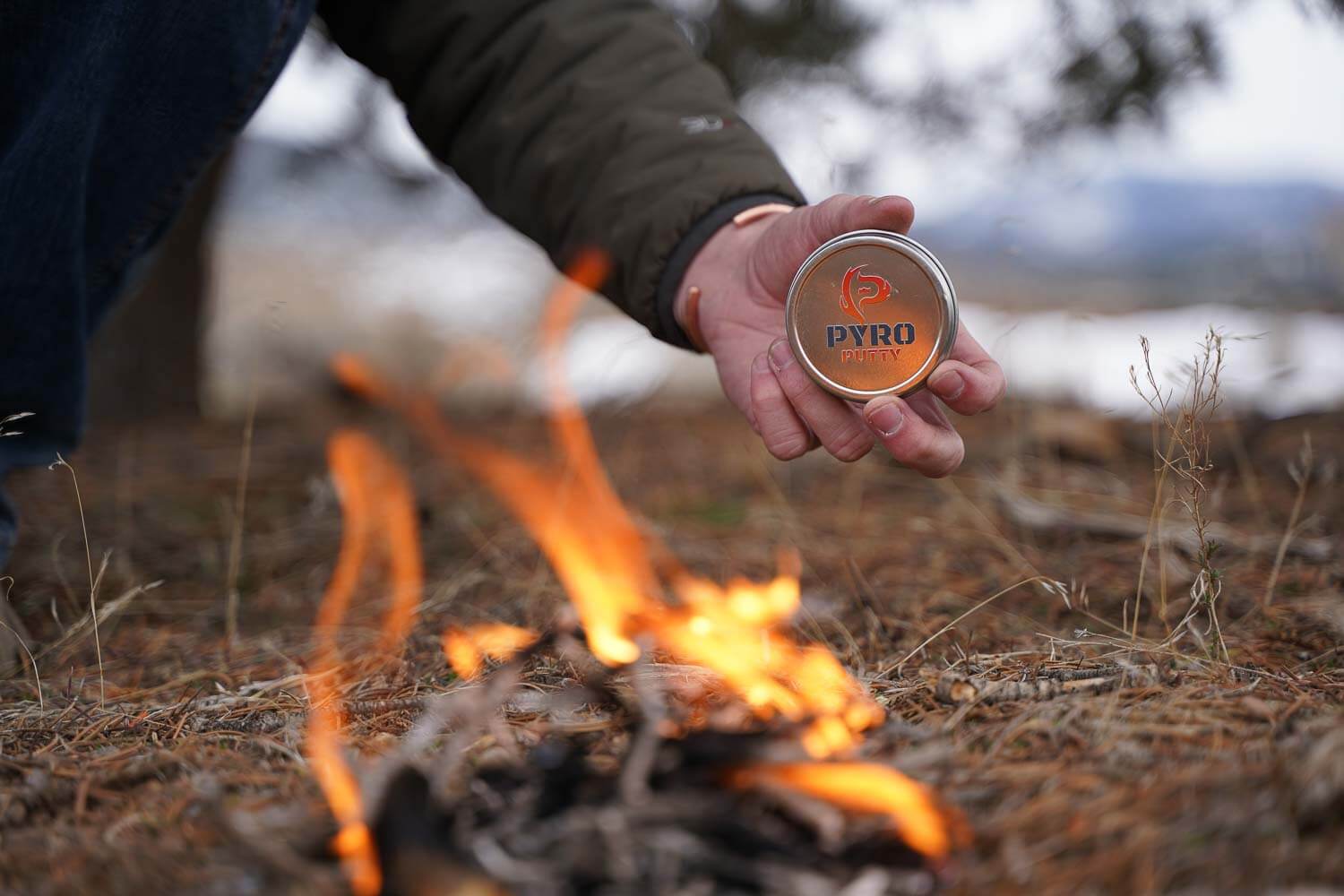 A can of PyroPutty in front of a burning fire