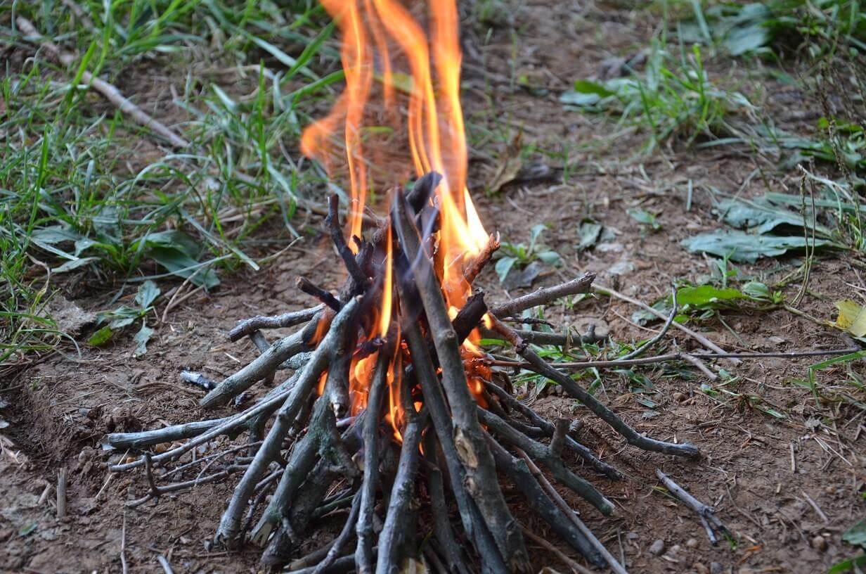 Wood in the form of a teepee that is on fire